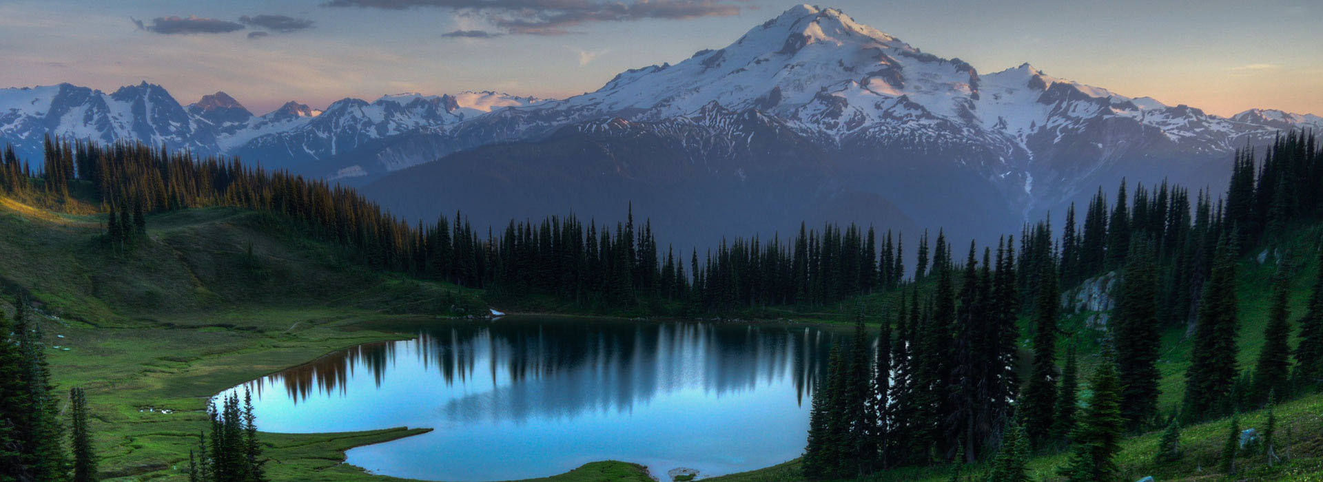 A lake with snow capped mountains in the background.